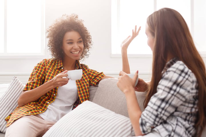 TWO WOMEN ARE TALKING TO EACH OTHER