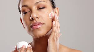 a girl is applying moisturizer on face : following glowing tips 