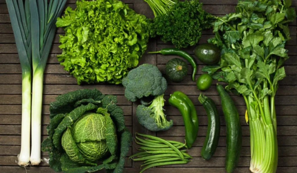 Variety of green vegetables are kept on table