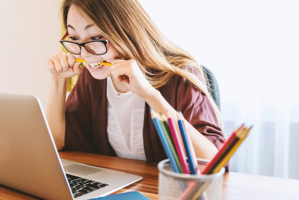 a women is sitting with keeping pen on her mouth